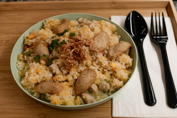 delicious bowl of fried rice with meatballs and onions on wooden tray