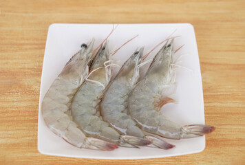 Four fresh river prawns placed neatly on  white square plate, ready for cooking. Concept, seafood ingredient for gourmet dishes. Thai cuisine, or grilling. Perfect for food lovers and culinary 