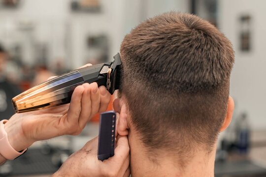 Barber giving a precise haircut to a client in a modern barbershop environment