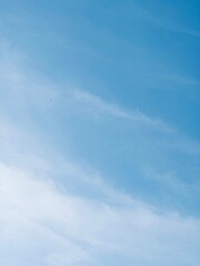 A panoramic view of the open blue sky with distant small kites flying, suggesting leisure, open air, and calmness.