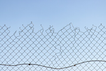 A chain link fence with a broken section