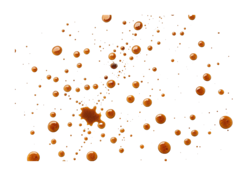 Droplets of coffee scattered in unique patterns against dark background