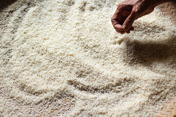 Hand inspecting rice grains on a woven surface, food preparation concept