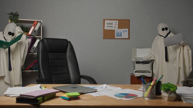Halloween businessmen ghosts in white sheets work at office, reading paper documents, copying and printing papers on printer. Happy halloween business concept.