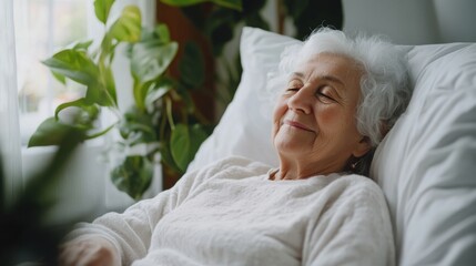 Elderly woman lying peacefully in bed near window in retirement home