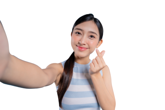 A lovely young Asian girl taking a selfie and making a trendy Korean mini heart gesture with her fingers.on png background
