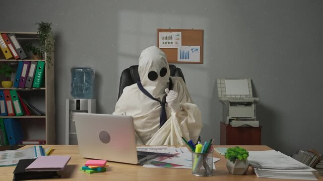 Halloween businessman ghost in white sheet works with papers and rejoicing. Happy halloween business concept.