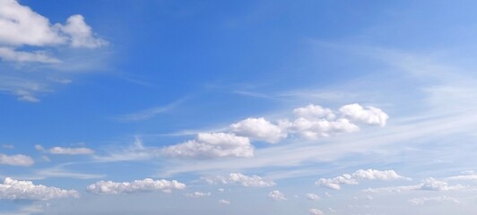 Panoramic cloudscape in clear blue sky in summer. Nature sky background with fluffy clouds.