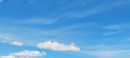 Obraz premium Panoramic cloudscape in clear blue sky in summer. Nature sky background with fluffy clouds.