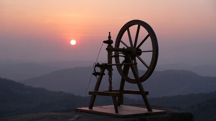 Wooden spinning wheel at sunset overlooking a mountain range mountains
