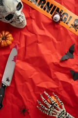 Intricate vertical setup of spooky Halloween objects including a skull, knife, skeleton hand, and...