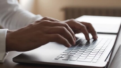 Close-up of a businessman's hands typing on a laptop keyboard. Professional man working online, using a computer in an office or for remote work. - Powered by Adobe