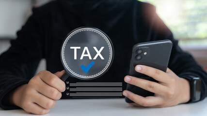 Tax planning and management concept using a smartphone, showing a magnifying glass with the word...