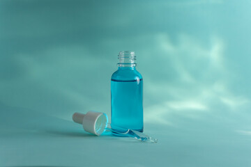 Botella gotero de cristal azul en un fondo acuatico
