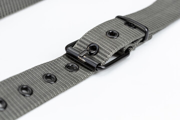 Close up of gray nylon belt with metal buckle, showcasing its durable design and multiple eyelets....