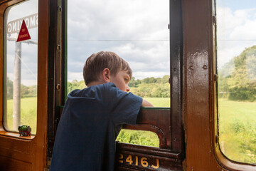 Small boy enjoying his journey on board a train of the Isle of Wight Steam Railway, Isle of Wight, England, UK. 
