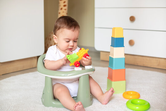 Baby playing with toy blocks sitting at home