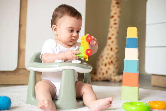 Baby playing with toy blocks sitting at home