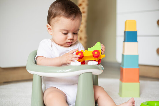 Baby playing with toy blocks sitting at home