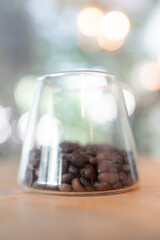 Clear jar filled with coffee beans on wood table