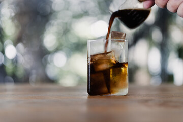 Iced americano coffee, an espresso coffee short pouring on water with iced cubes in a transparent glass © Dontree