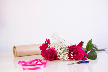bouquet of roses is being collected on table in flower shop. Valentine's Day. An atmosphere of creativity and inspiration.