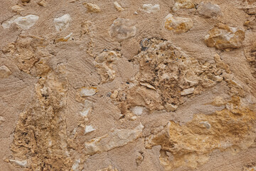 Textured wall in Crete with embedded stones, unique stone wall surface, natural background