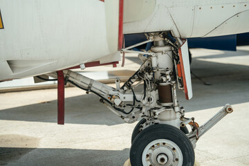 Close-up view of the complex nose landing gear system of a military aircraft. Visible are the hydraulic lines, metal struts, and mechanical components used in landing operations.