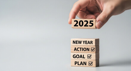 Hand placing word blocks, 2025 resolution, goal setting, strategic planning, action steps.