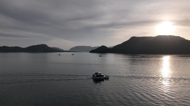 Sunset Drone Tracking Boat Across Sea Outside Langkawi Resort with View of Rebak Island, Tuba Island, Dayang Bunting, and Beras Basah Islands