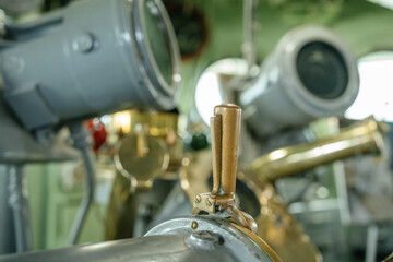 Detailed view of a bronze lever attached to classic ship navigation machinery. The equipment is...