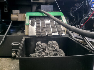 Process of recycling rubber material in a machinery workshop during daylight at an industrial...