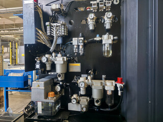 Complex hydraulic control panel in a modern manufacturing facility showcasing industrial equipment