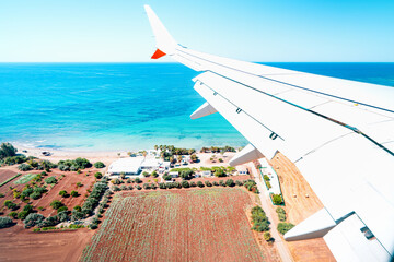 Airplane wing against the turquoise sea, Cyprus. Travel concept.