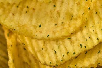Golden potato chips are layered neatly, showcasing their ridged texture