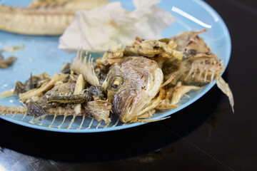 Delicious dorado fish served on a plate showcasing its crispy, golden skin and delicate bones after a satisfying meal