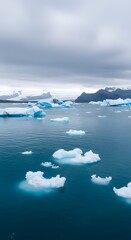 Obraz premium Jokulsarlon Glacier Lagoon: Icebergs Floating in Serene Blue Waters Under Cloudy Skies