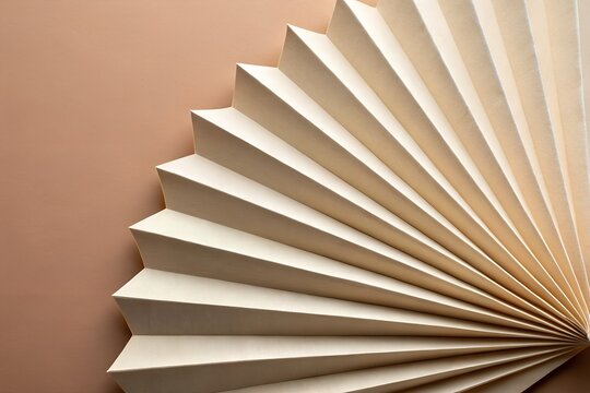 Pleated beige material folds create a beautiful fan pattern with textured surfaces against a simple brown background.