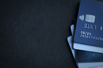 Many different credit cards on black table, top view