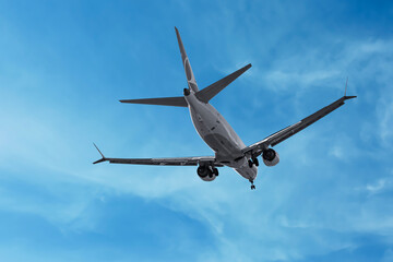 Airplane flying in beautiful blue sky with clouds