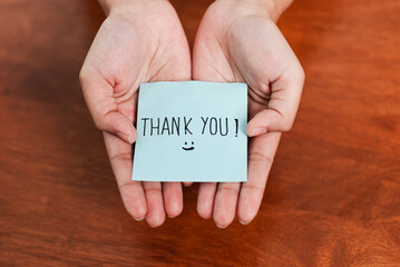 Gratitude gesture thank you note in hands home setting personal moment warm environment close-up view