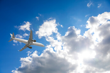 Airplane flying in beautiful blue sky with clouds