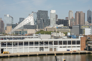 A modern triangular building stands out among New York City skyscrapers. The foreground shows a...