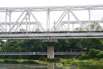 A truss bridge and a footbridge spanning the river