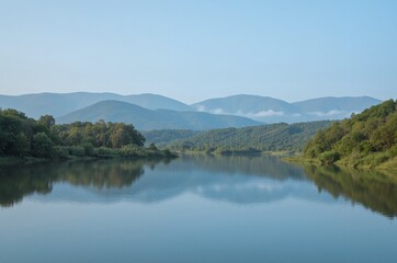 Crystal Clear Lake Against Lush Green Forested Mountains At Sunrise Under Clear Sky