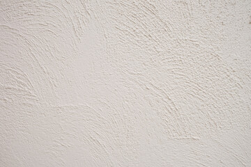 The cement wall is in white, off-white, and has a pale-yellow tone; the wall has a line texture pattern.