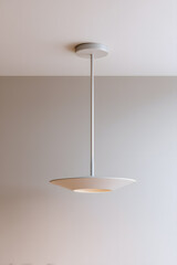 Elegant minimalistic ceiling lamp on light wall. Perfect for architectural renders, interior mockups, and modern lighting design visuals.