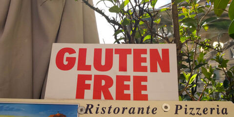 Gluten-free sign displayed outside a restaurant, indicating dietary options for customers in a vibrant setting