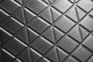 Fototapeta premium Luxurious brushed platinum surface with geometric diamond pattern reflecting studio lights
