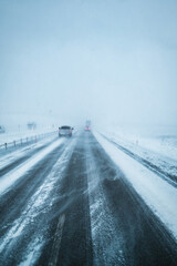 Winter storm with snow covered road and car driving condition in snowy weather and poor visibility...